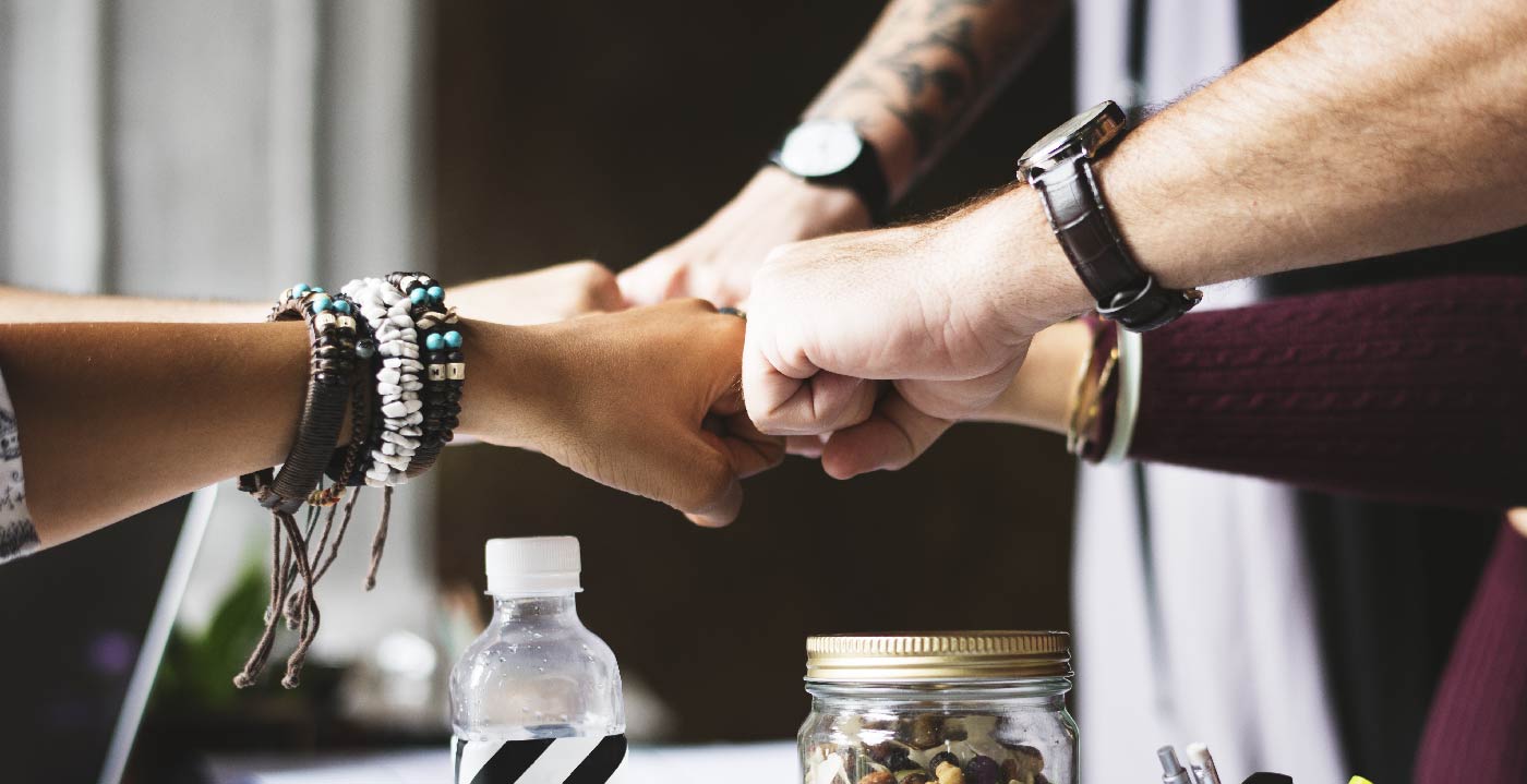 A team putting their hands in together before an escape room game